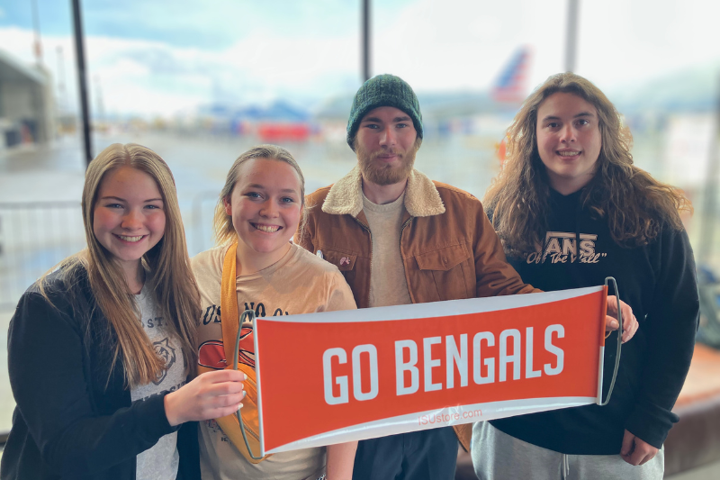4 students hold a banner that says
