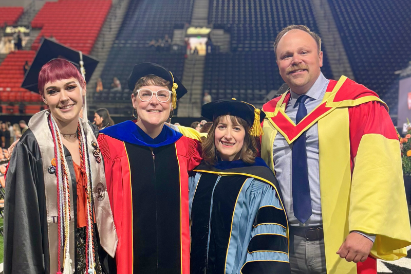 student with faculty at graduation