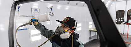 Auto Collision student painting a car door