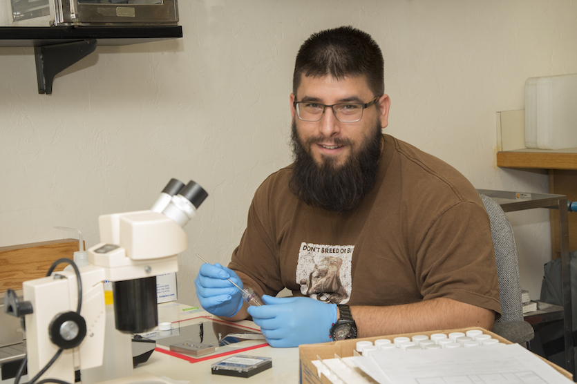 Jeremy Starkey working with a microscope in the lab.