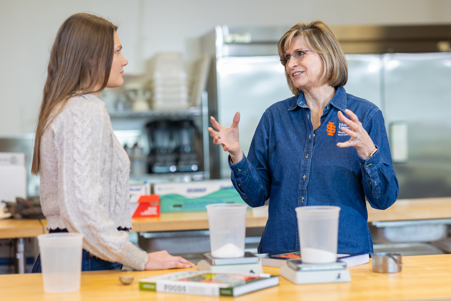 Two women talk in a food laboratory