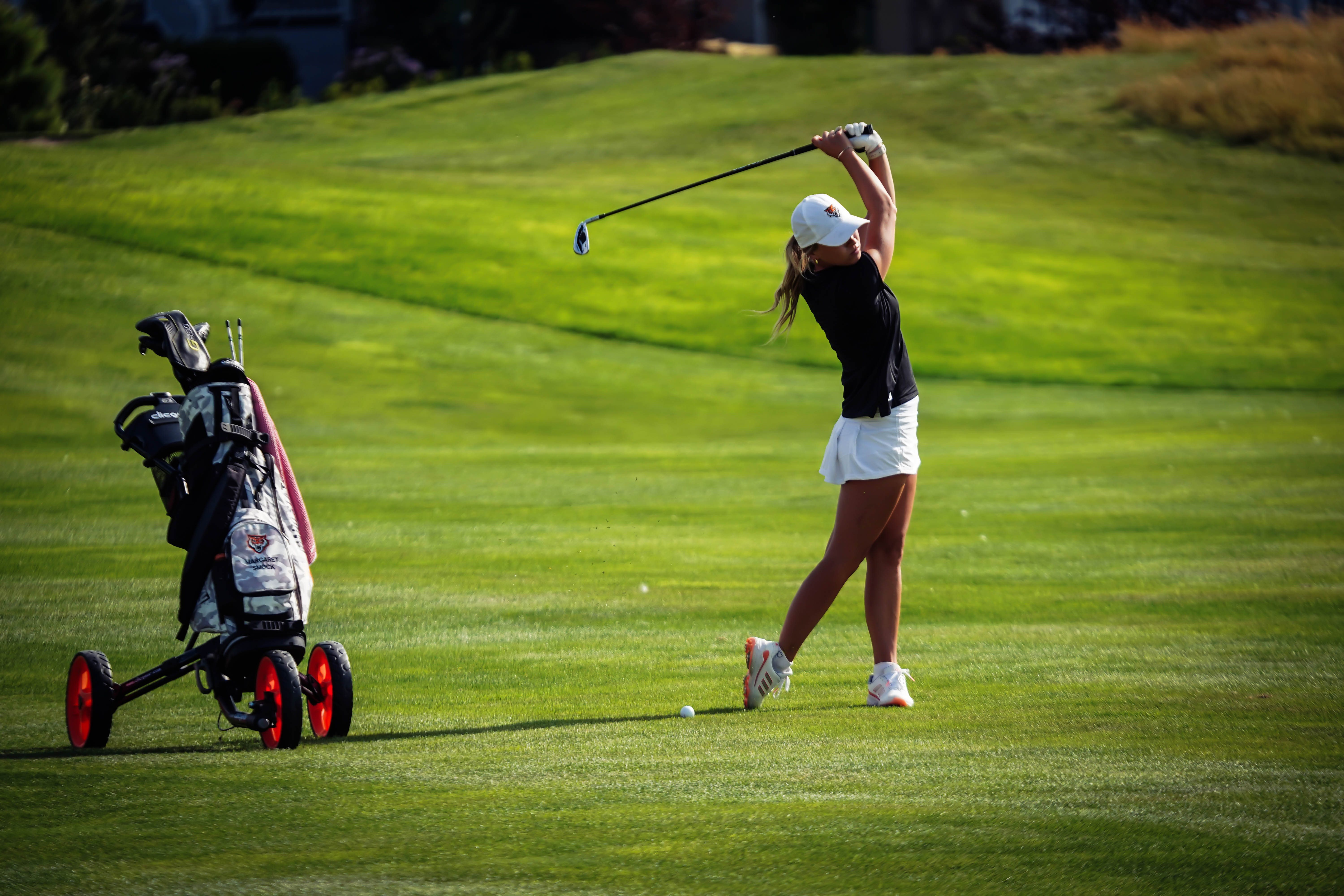 Student golfing mid-swing