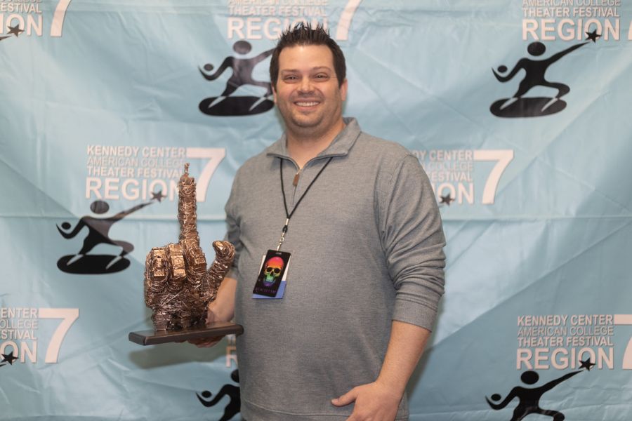 Paul Yeates holding Golden Hand Truck award. The award is a metal statue of a hand with a pointed index finger