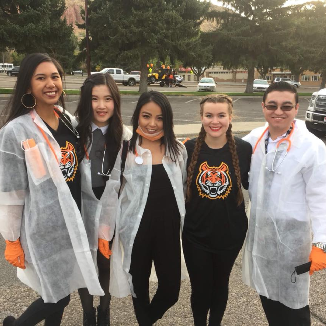 5 students in bengal shirts and lab coats stand outside posing for a picture together