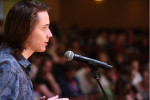 A close up of a student in profile at a microphone