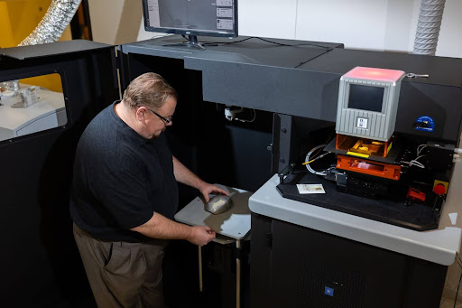 ISU’s new instrument allows for larger sample sizes than have been possible before. Andy Speer loads a sample in the sample chamber, which is about the size of a mini-fridge.