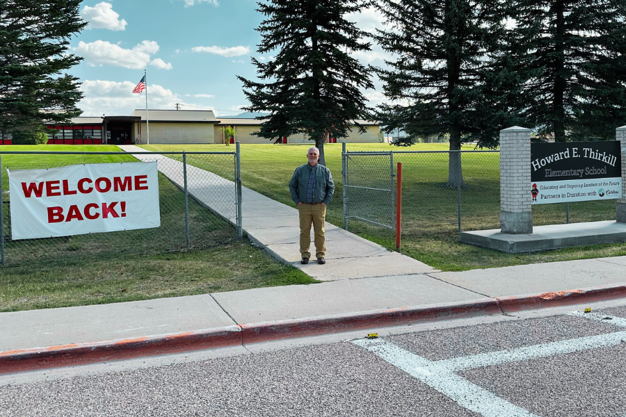 Muir stands in front of school grounds with a 