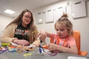 Idaho State University elementary education graduate works with a elementary student teaching them science, technology, engineering, and mathematics skills and knowledge in a classroom.