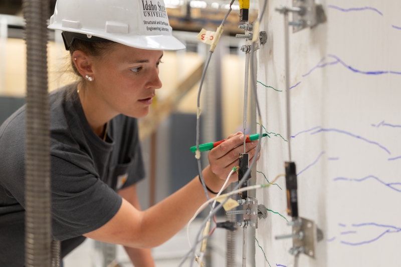 Katie Hogarth, a doctoral student studying civil engineering at Idaho State University in Pocatello, takes measurements on a reinforced concrete column.