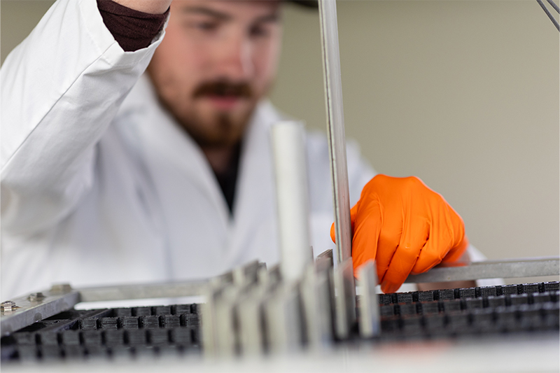 Idaho National Laboratory employee Carter Johnson inserts a uranium-235 fuel plate into ISU's subcritical assembly.