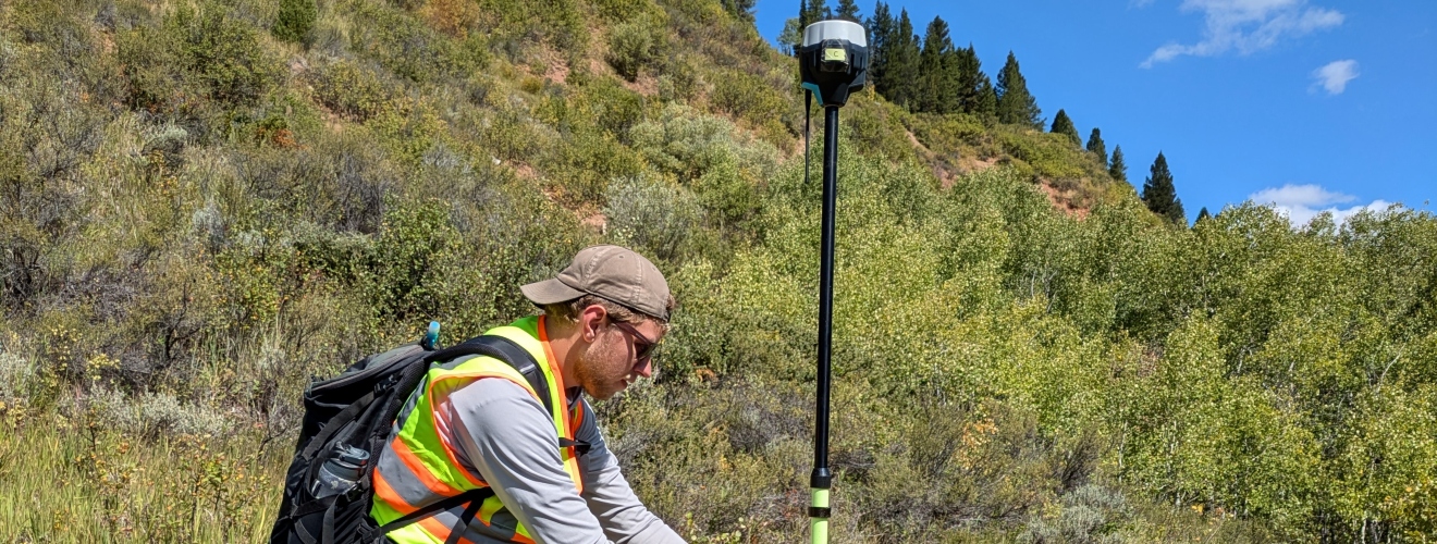 A student works with a piece of Geospatial Equipment in the field