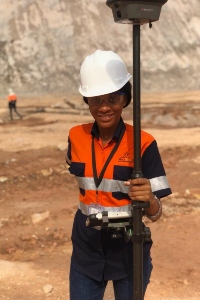 Betty Brown wearing a safety vest while holding high-tech GIS devices