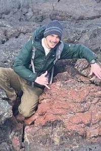 David Cavell posing with a lava rock