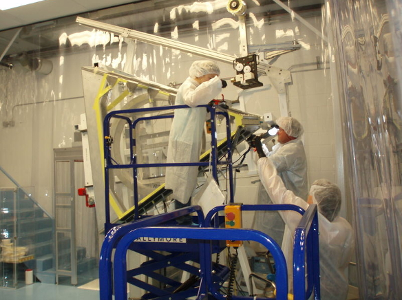 People in lab coats working on some equipment