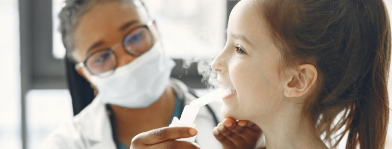 A health professional helping a young girl with athsma