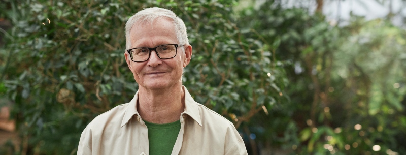 An elderly man standing and smiling