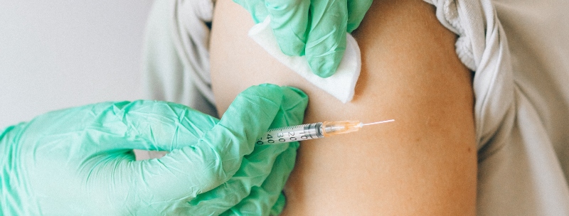 A medical professional about to administer an immunization into an arm