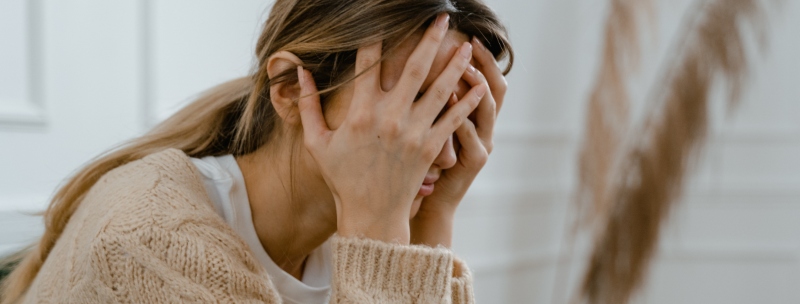 A woman sitting with her head in her hands in distress