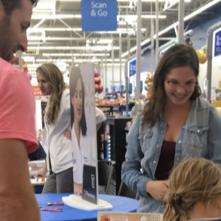 Graduate nutrition student discusses nutrition with father and daughter in Walmart Store