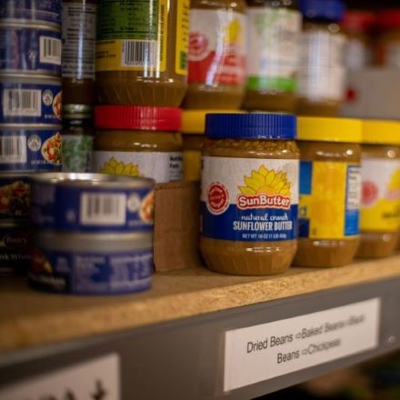 Canned goods, nut butters on food pantry shelf