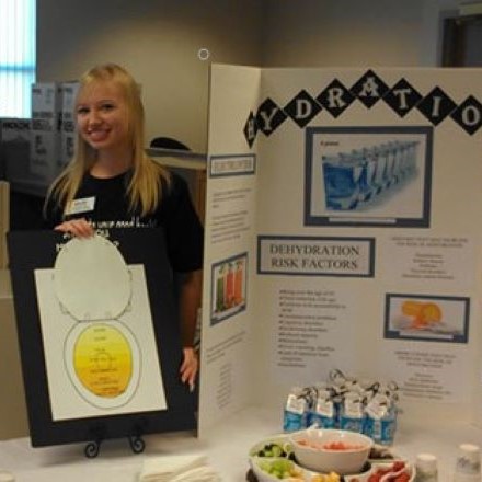 Nutrition student at community health fair, educating seniors about the importance of staying hydrated
