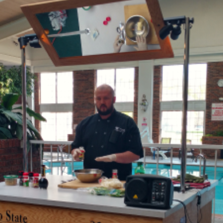 Male nutrition student doing cooking demonstration at community health fair