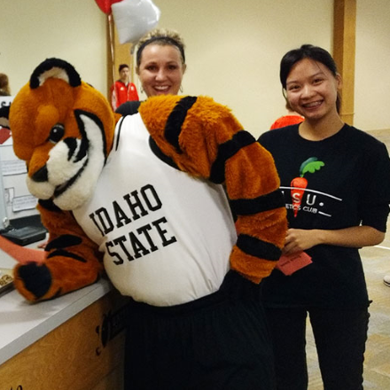Nutrition majors at community health fair talking with Benny the Bengal