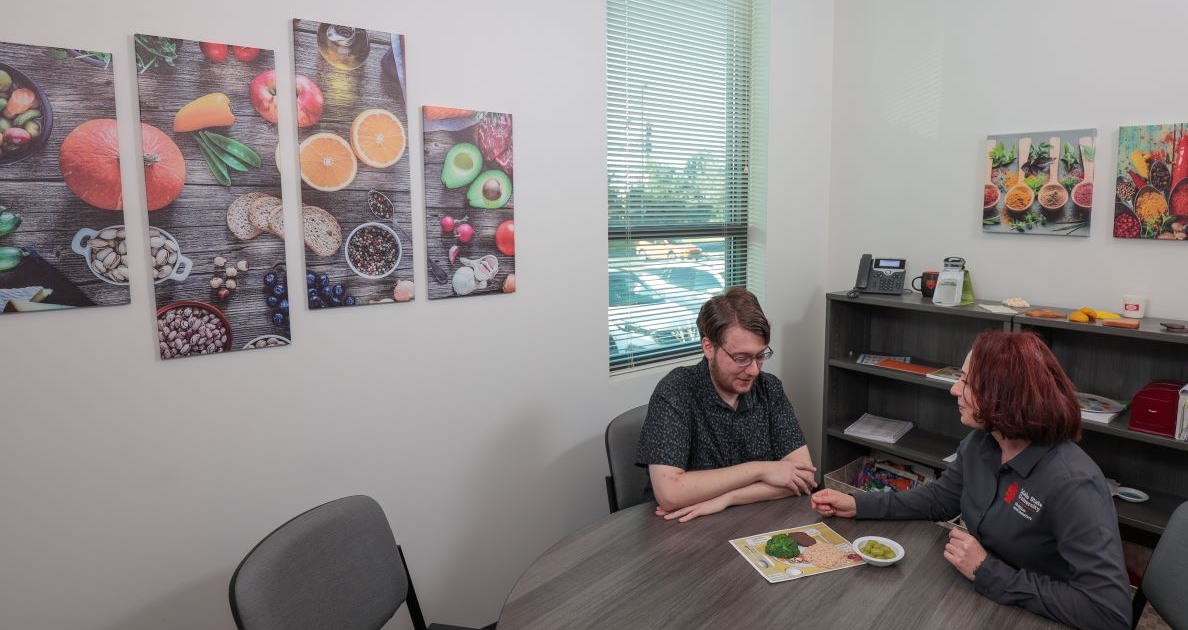 A professor and a dietetics student sitting at a table