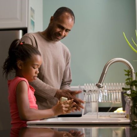 Father of color making breakfast with his daughter