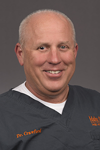 Brian Crawford, DDS, in gray and orange ISU scrubs