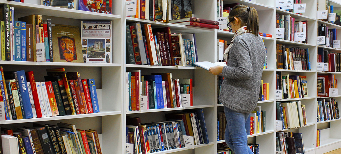 Woman perusing books in a library