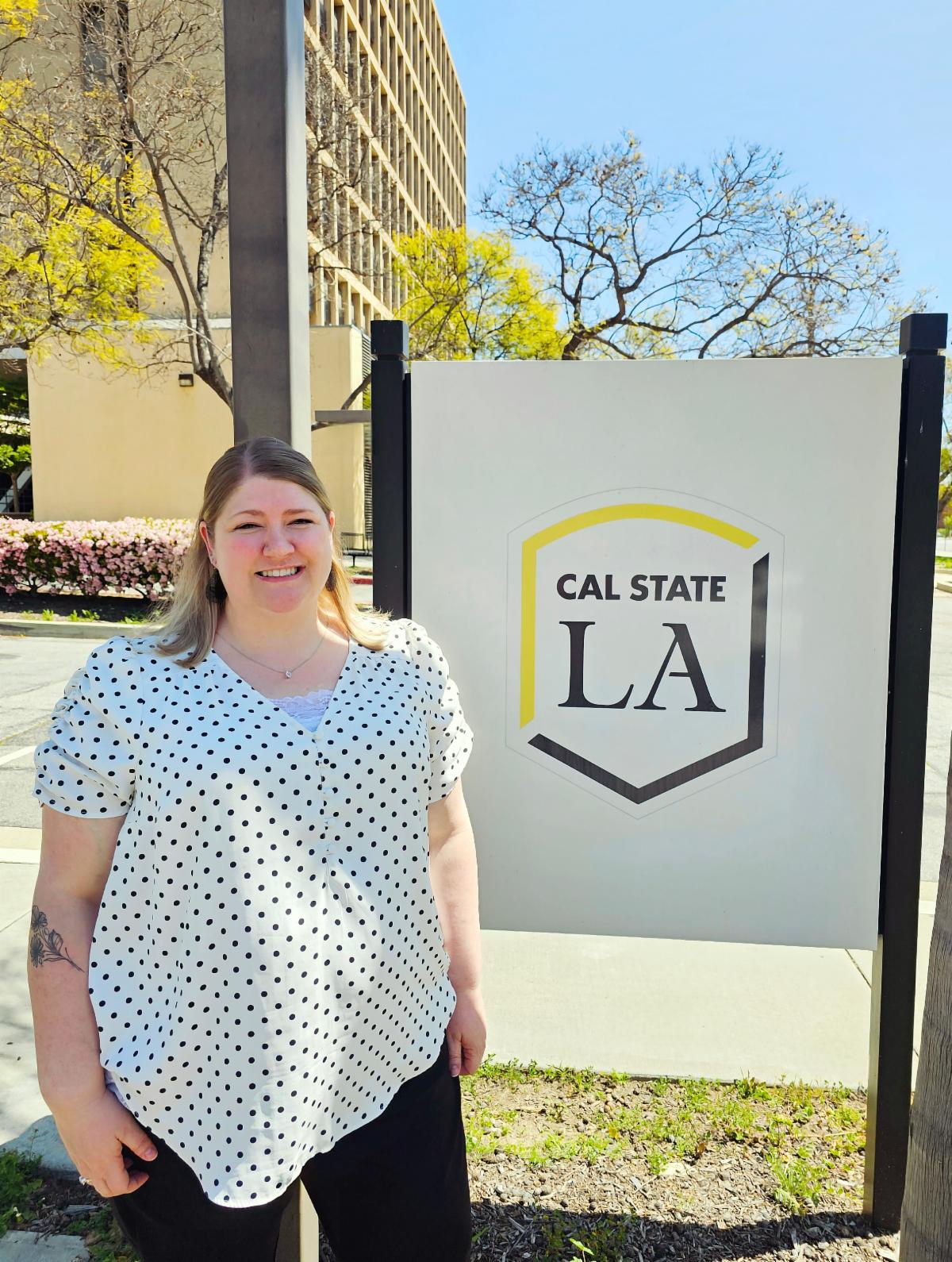 Amanda Stevens posing in front of the CAL State LA campus sign