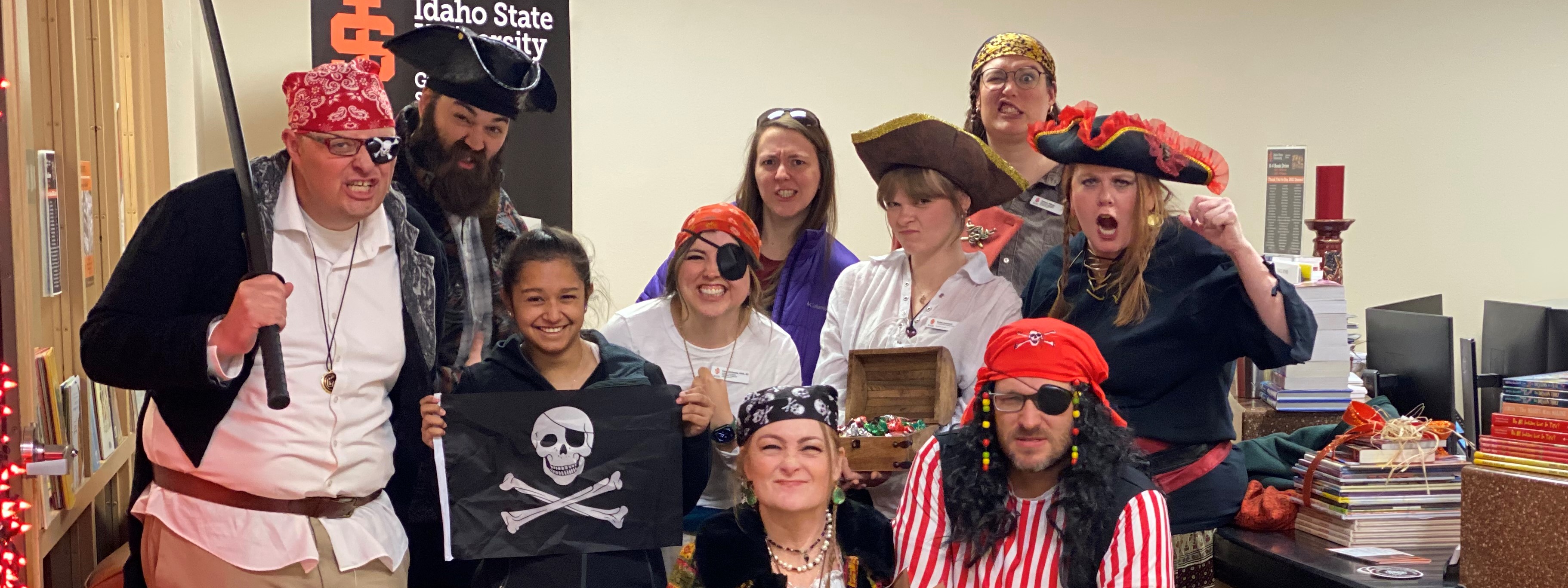 The graduate school team dressed as pirates for Halloween making grumpy faces
