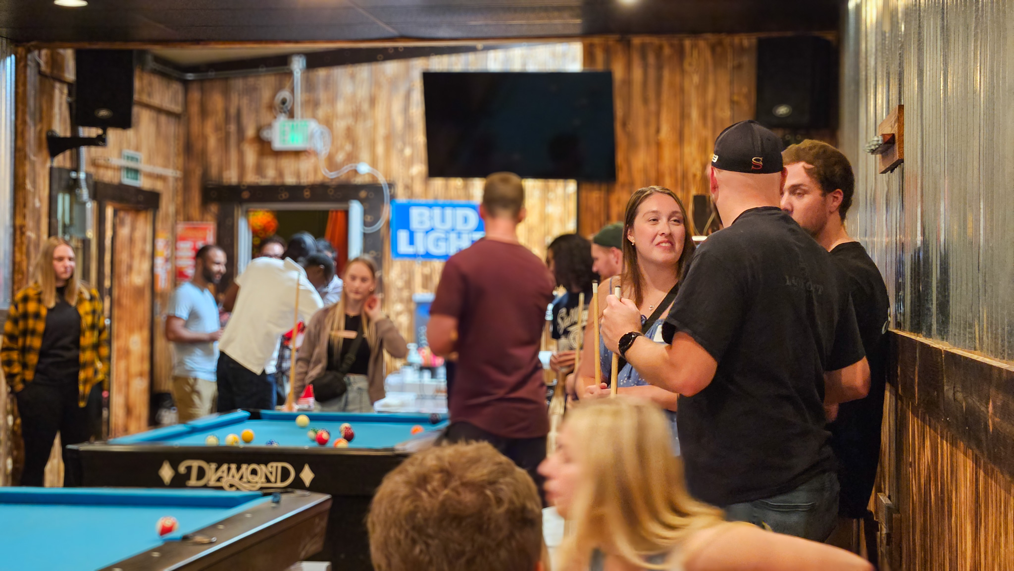 A room full of students at Late Nights playing pool