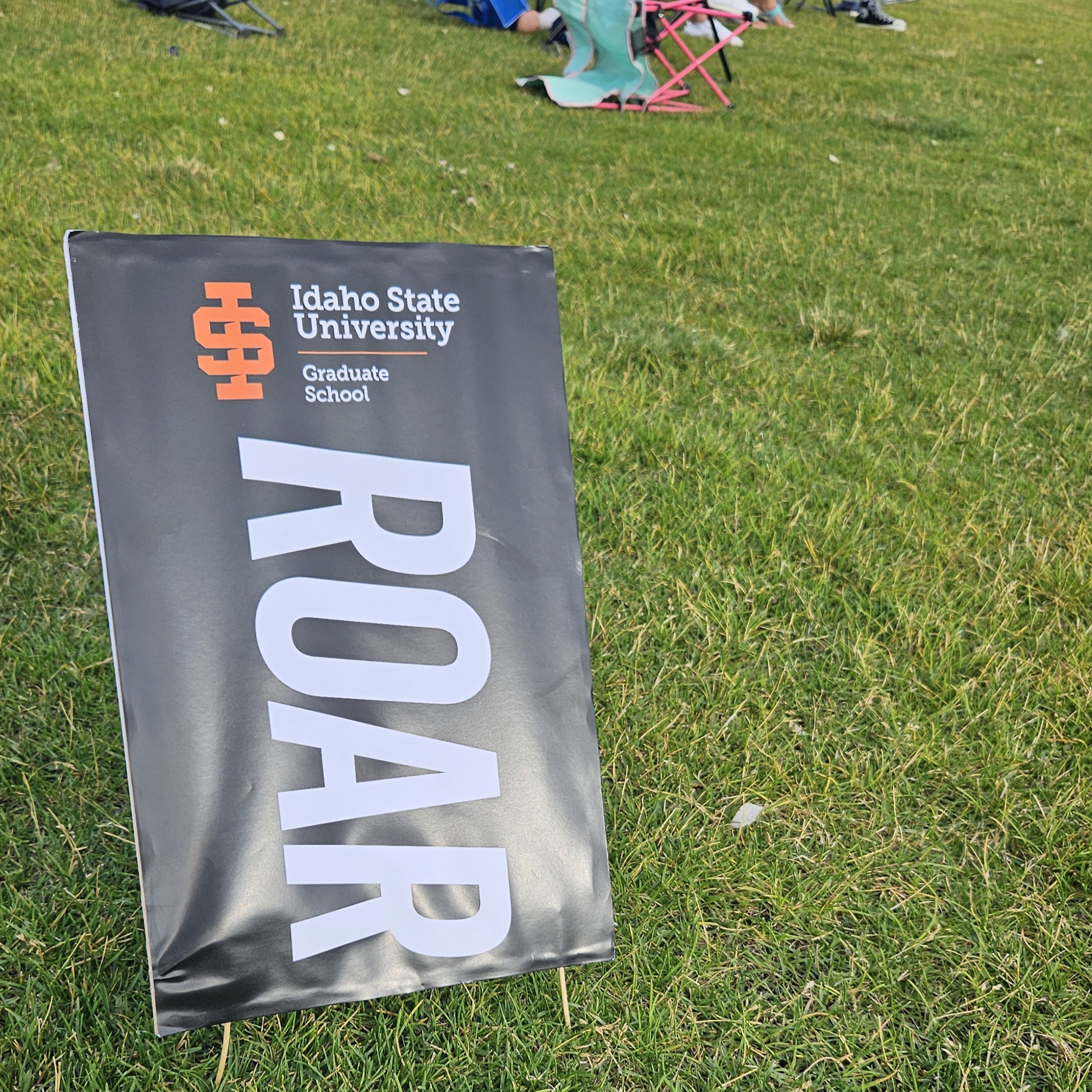 The graduate school ROAR sign in the grass