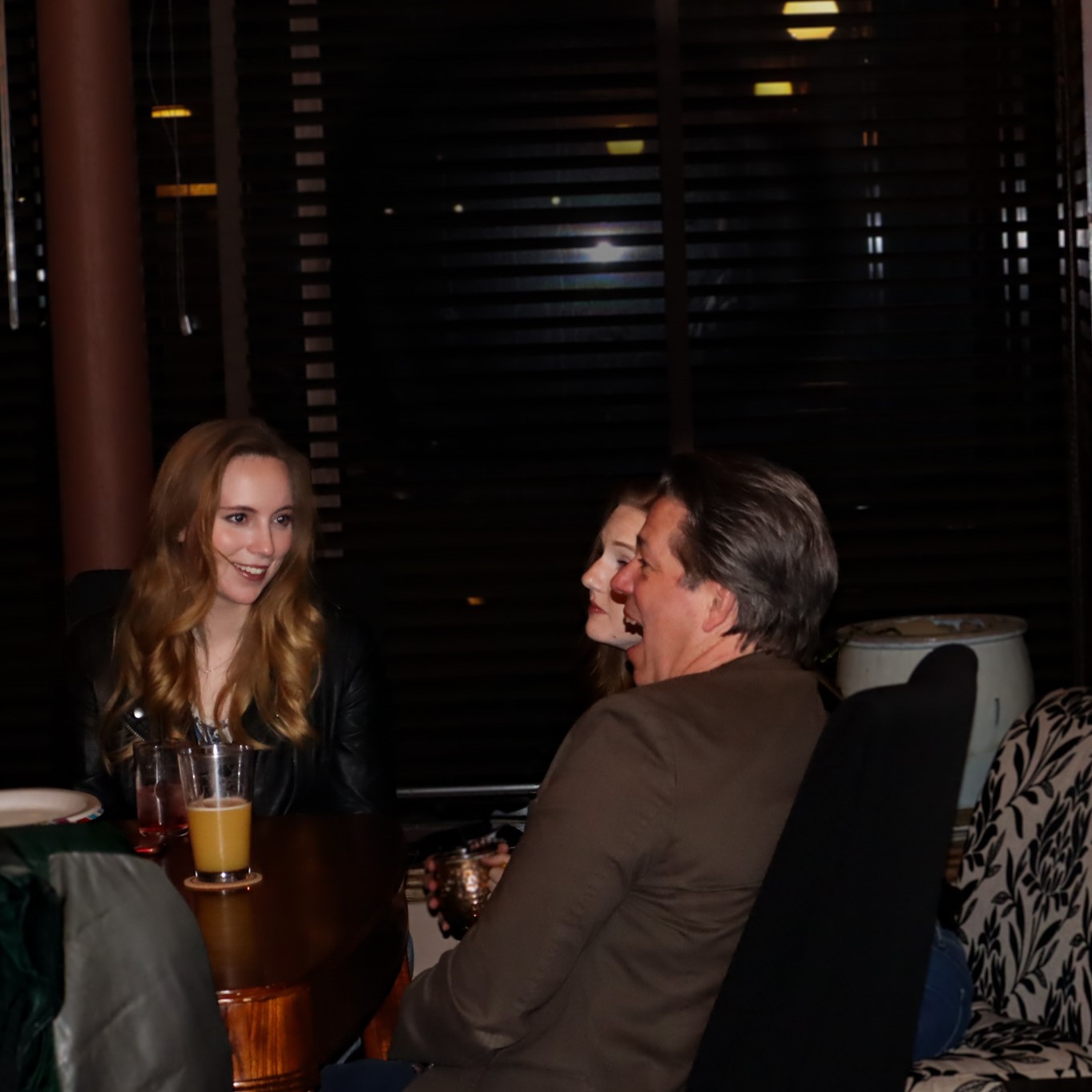 a group of grad students conversing at a long table at late nights