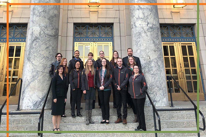Students in gray pharmacy jackets stand with College of Pharmacy leadership on the steps of the Alaska Capitol Building during UAA ISU Capitol Fly-In Day 2019