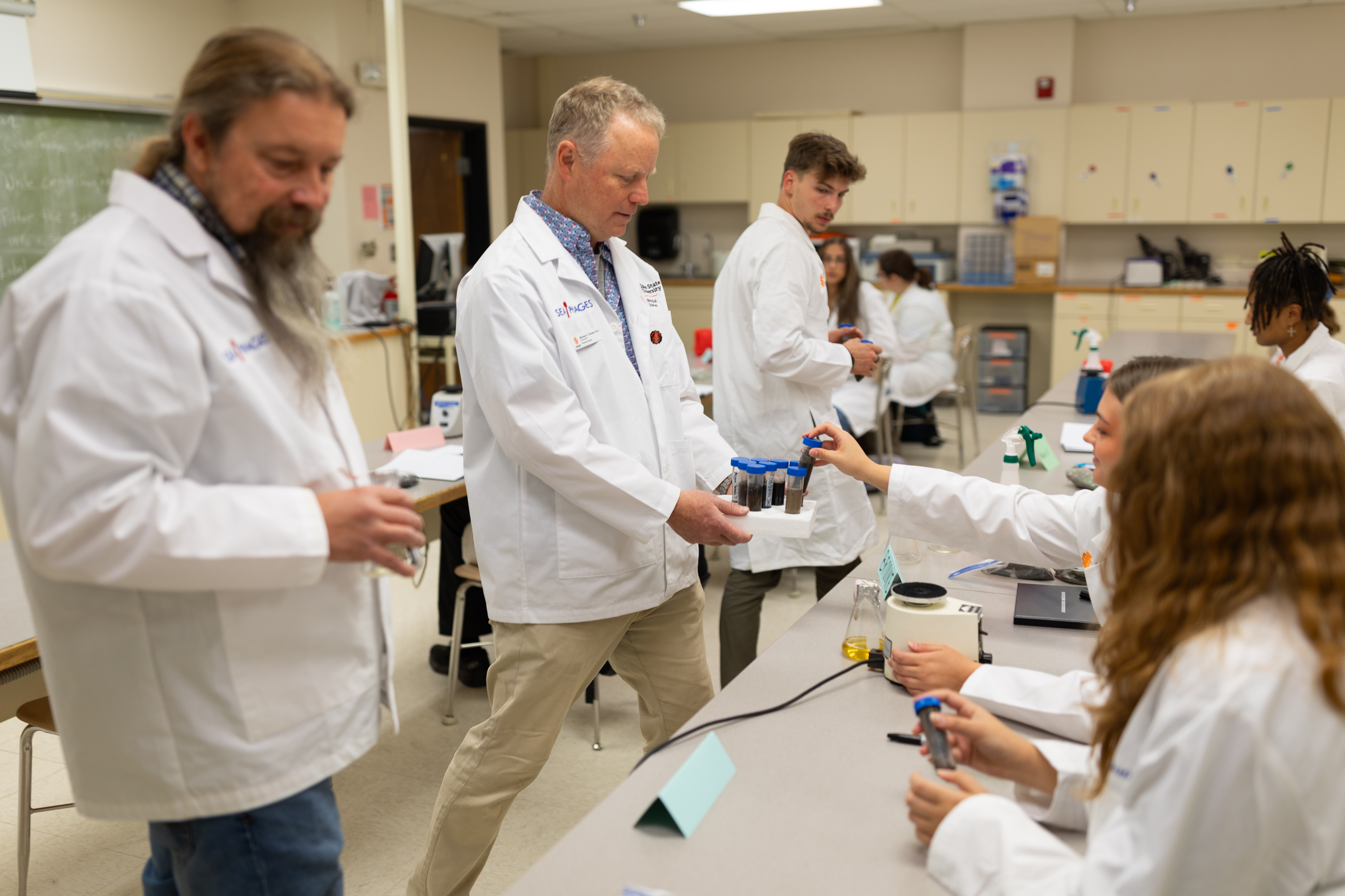 Michael Thomas, professor in the Department of Biological Sciences,helps students with their samples in the Bacteriophage Discovery and Genomics class