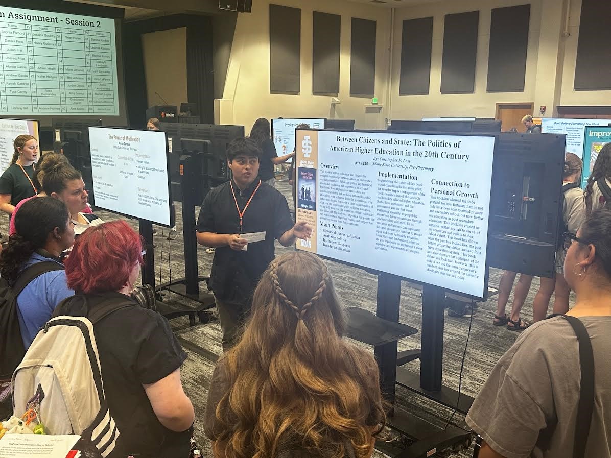 Student presenting to peers at the poster session