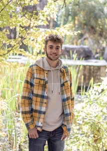 A student standing in the grass.