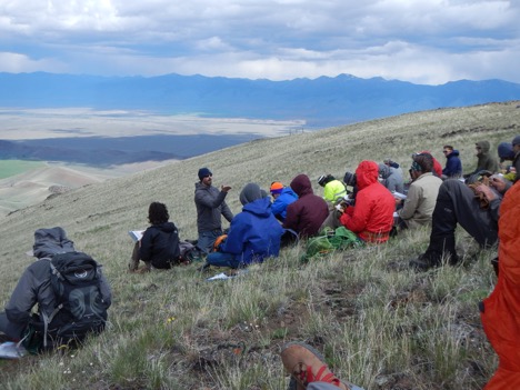 Dr. Ben Crosby lecturing to students in the wind in the Pahsimeroi Mountains.  The Lemhi Range forms the background.   June 2016