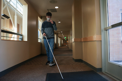 Bryant Walker, a senior pursuing a degree in communications, uses his cane to get to his dorm room at Idaho State University's Pocatello campus on Wednesday, November 17, 2021. Photo by Johnathan Roark, University Photographer