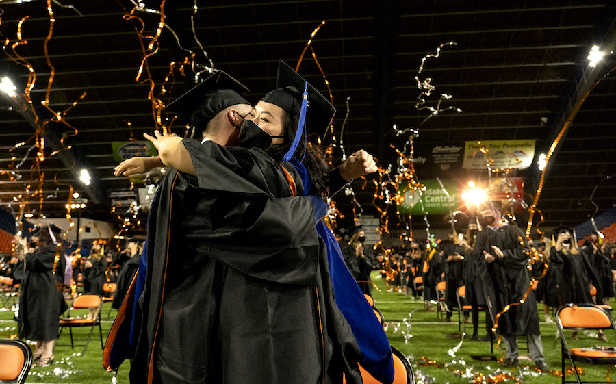 A couple hugs at 2021 Commencement