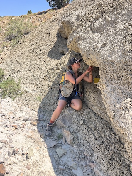 Woman looks at a rock cliff