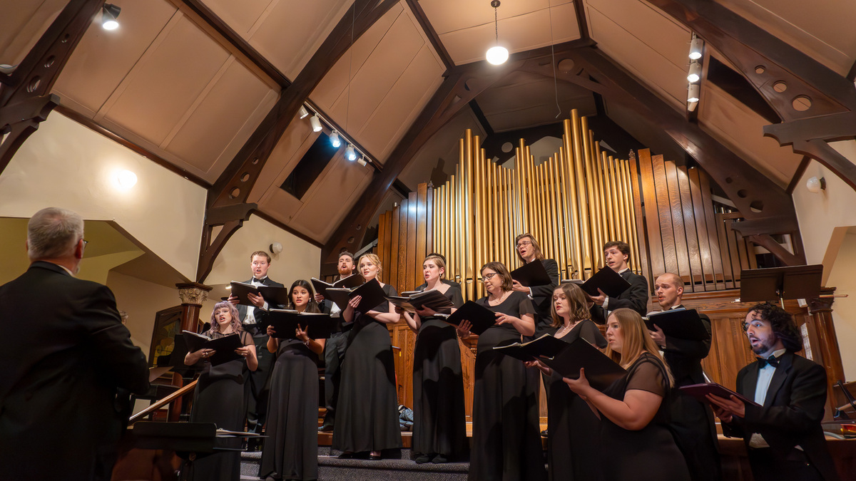 Members of the ISU Chamber Choir in formal dress perform in a church