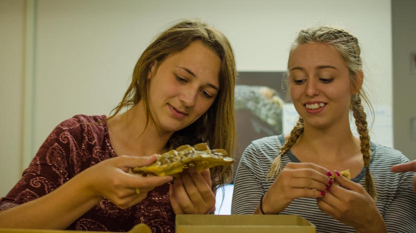 A photo of the two NASA interns featured in the story looking at a museum fossil.