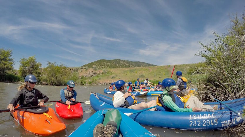 Picture of field trip participants on a river in kayaks and inflatable canoes.