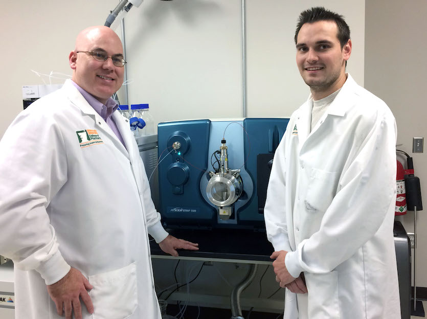 Dr. Kirk Hevener (left) and lab assistant Ben Walsh, who is working on his master’s degree in medical laboratory science, stand next to the new SCIEX QTRAP® 5500 LC-MS/MS system at ISU-Meridian.