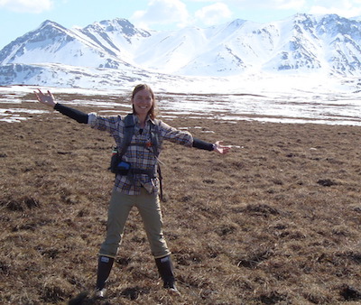 Photo of Caitlin Rushlow in Arctic with mountains in background.