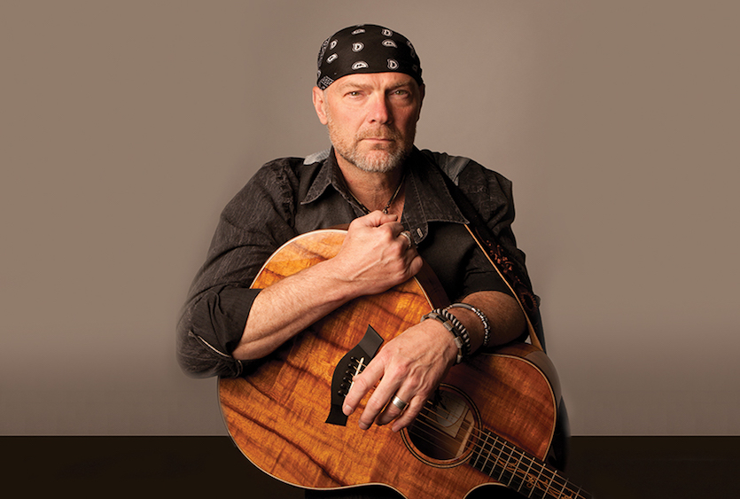 Photo of Les Stroud holding guitar
